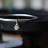 Silver bangle with solid 9ct gold small pebble